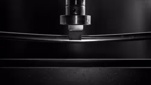 tubo quadro a raggio lucidato a specchio in acciaio inox sottoposto a stress test sotto un braccio idraulico