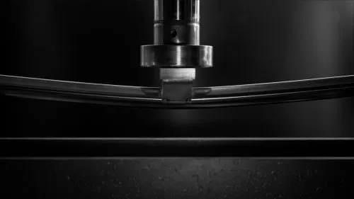 tubo quadro a raggio lucidato a specchio in acciaio inox sottoposto a stress test sotto un braccio idraulico